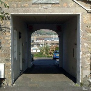 A view of the harbour through an arch in Chapel Street, site of the old Pen